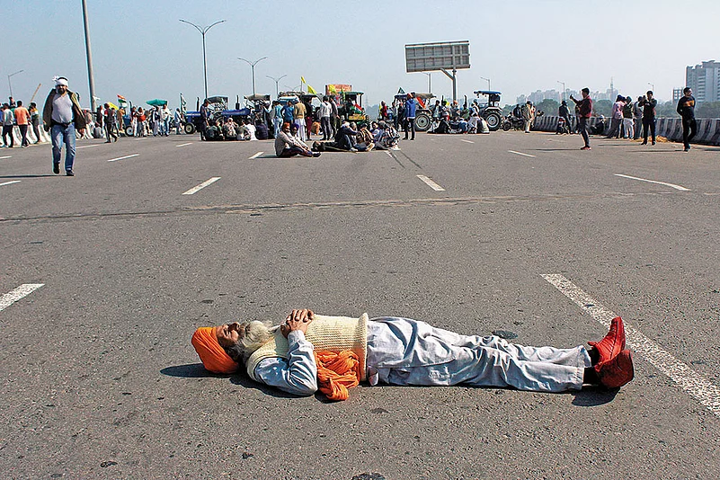 A protesting farmer lies down on the highway as part of a demonstration