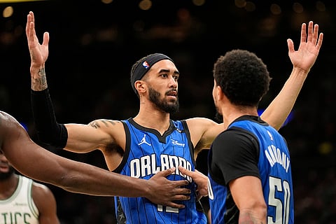 NBA 2024-25: Magic's Trevelin Queen (12) disputes a foul called on him as Cole Anthony keeps him away from the referee