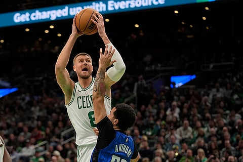NBA 2024-25: Celtics' Kristaps Porzingis (8) shoots over Magic's Cole Anthony