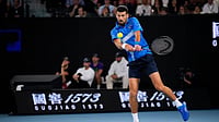 (AP Photo/Vincent Thian) : Novak Djokovic of Serbia plays a backhand return to Carlos Alcaraz of Spain during their quarterfinal match at the Australian Open tennis championship in Melbourne, Australia, Tuesday, Jan. 21, 2025. 