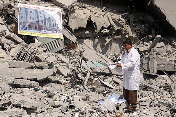 Getty Images : Palestinian doctor inspects devastation the headquarters of El-Wafa rehabilitation hospital