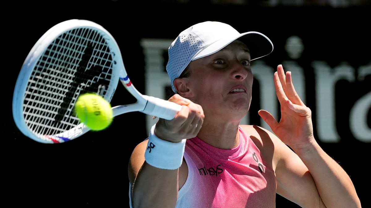 AP Photo/Manish Swarup : Iga Swiatek of Poland plays a forehand return to Emma Navarro of the U.S. during their quarterfinal match at the Australian Open tennis championship in Melbourne, Australia.