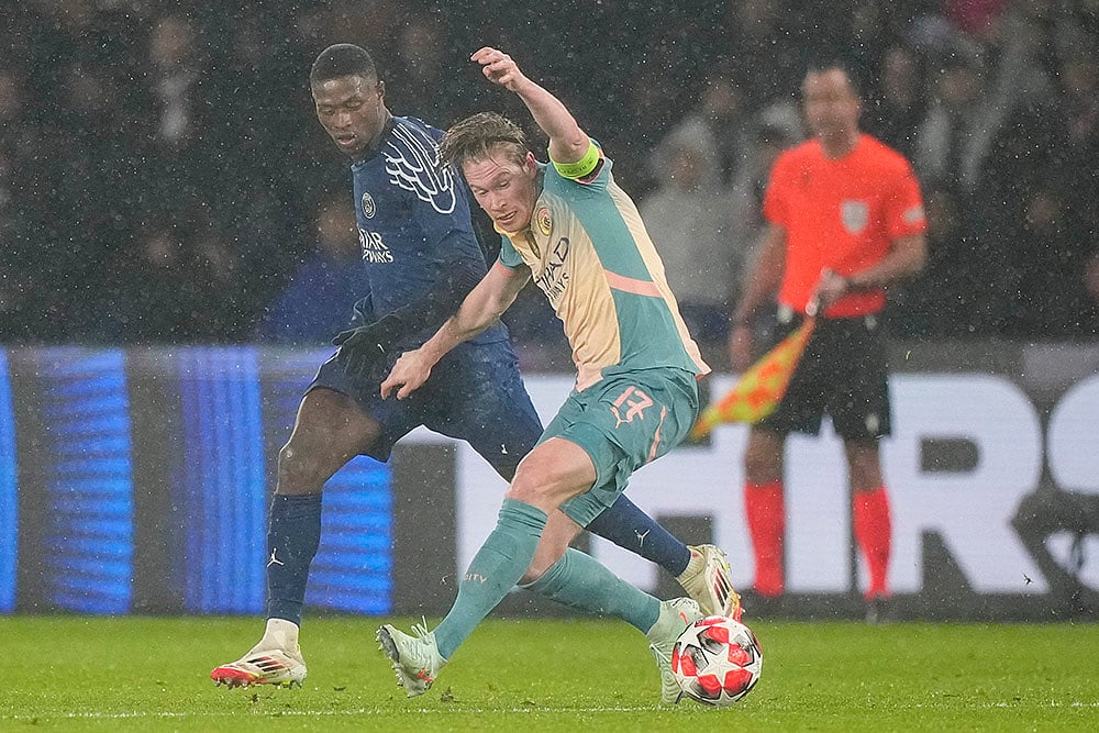 | Photo: AP/Michel Euler : Champions League 2024-25: Manchester City's Kevin De Bruyne, right, is challenged by PSG's Nuno Mendes 