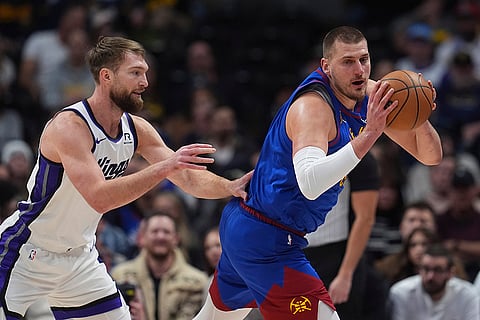 NBA Basketball 2024-25: Nuggets Nikola Jokic collects the ball as Kings Domantas Sabonis defends
