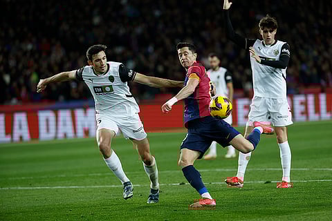 La Liga 2024-25: Valencia's Cesar Tarrega and Barcelona's Robert Lewandowski challenge for the ball