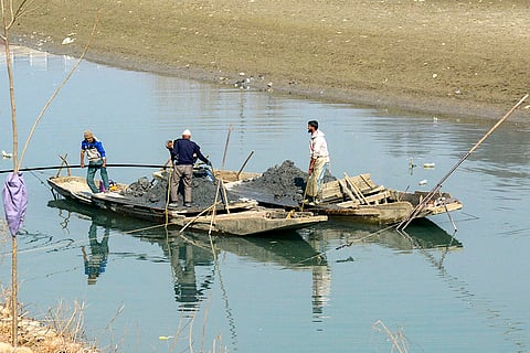 Workers extract sand