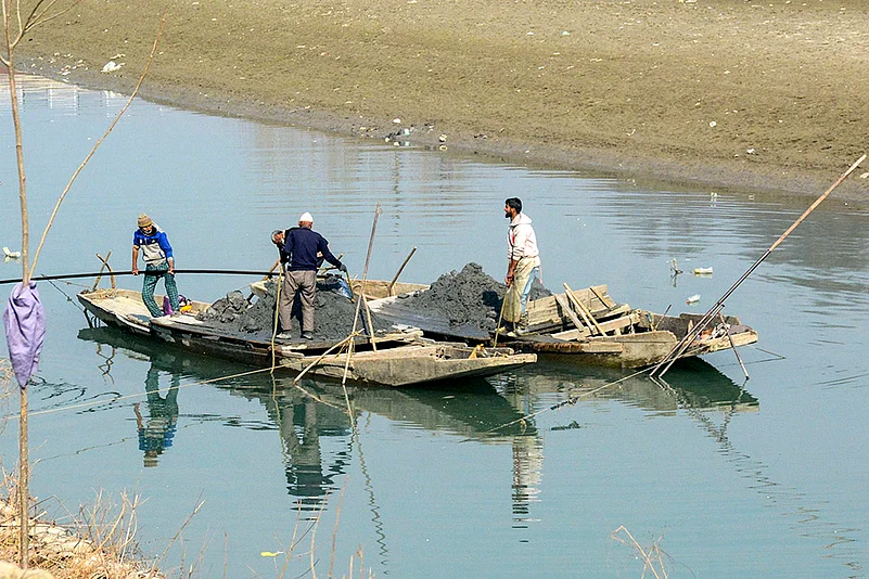 Workers extract sand
