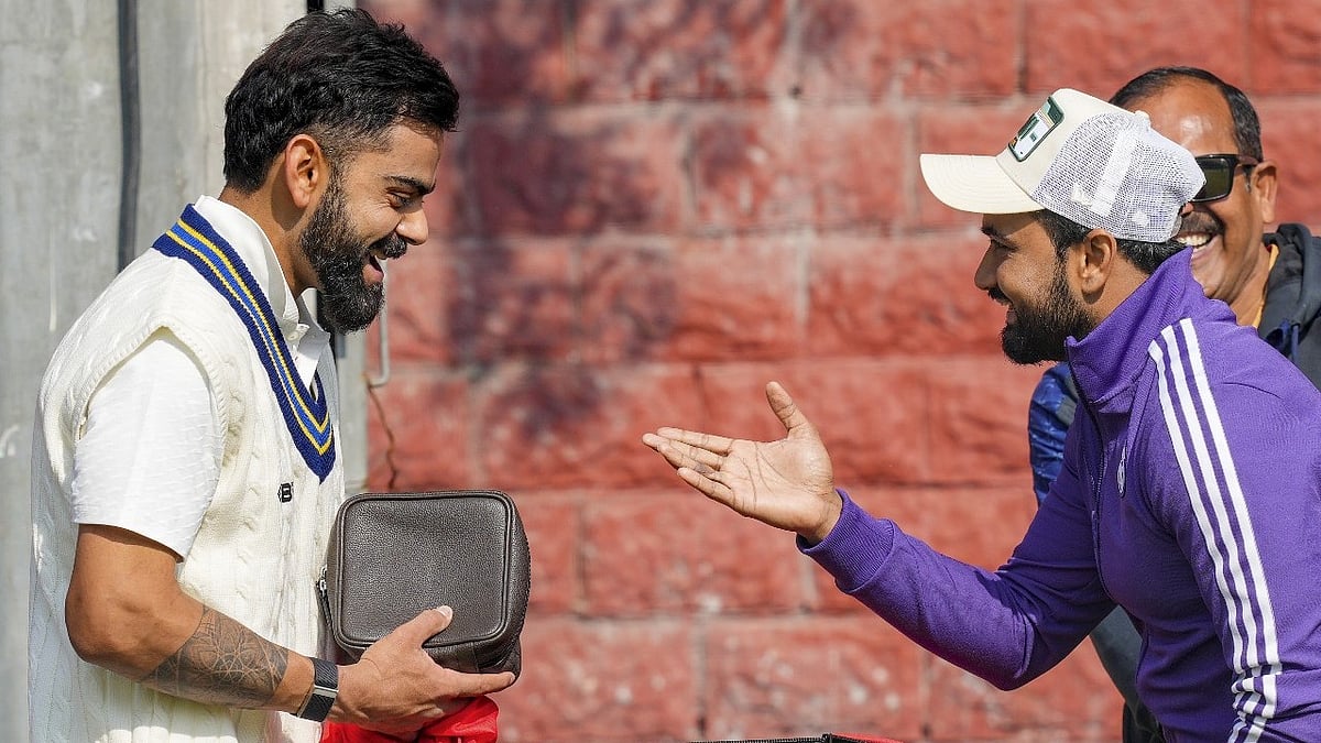 Delhi's player Virat Kohli shares a light moment with his former cricket mate Shavez during a training session ahead of the Ranji Trophy 2024-25 cricket match between Delhi and Railways, at the Arun Jaitley Stadium, in New Delhi, Tuesday, Jan. 28, 2025 - PTI Photo/Kamal Kishore