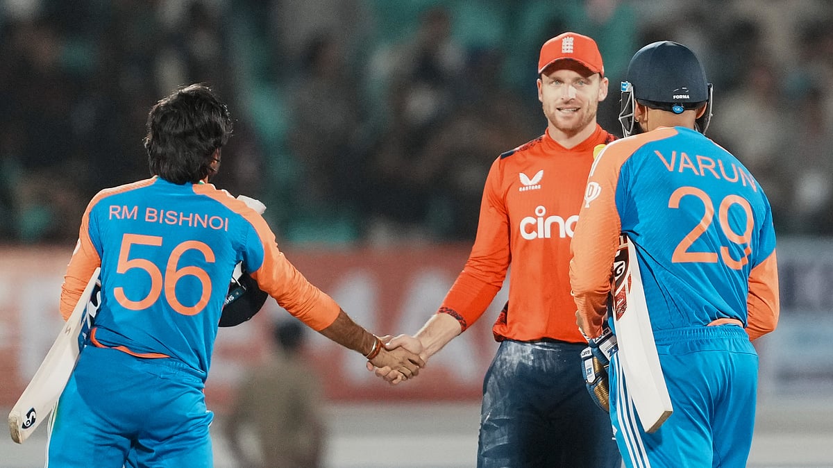 PTI Photo/Kunal Patil : England's Jos Buttler shakes with India's Ravi Bishnoi after his team's win in the third T20 cricket match against India at the Niranjan Shah Stadium in Rajkot.