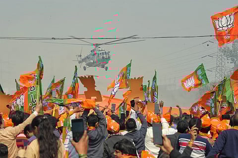 BJP supporters wave flags at PM Modi's helicopter