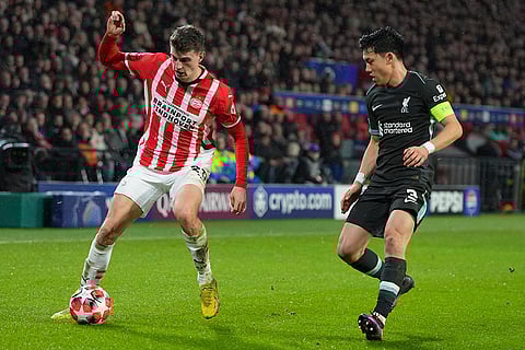 Champions League 2024-25: PSV's Guus Til in action by Liverpool's Wataru Endo