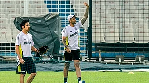 AP Photo/Bikas Das : India's captain Surya Kumar Yadav, right, gestures as chief coach Gautam Gambhir looks on during the practice session ahead of their first T20 match against England, in Kolkata.