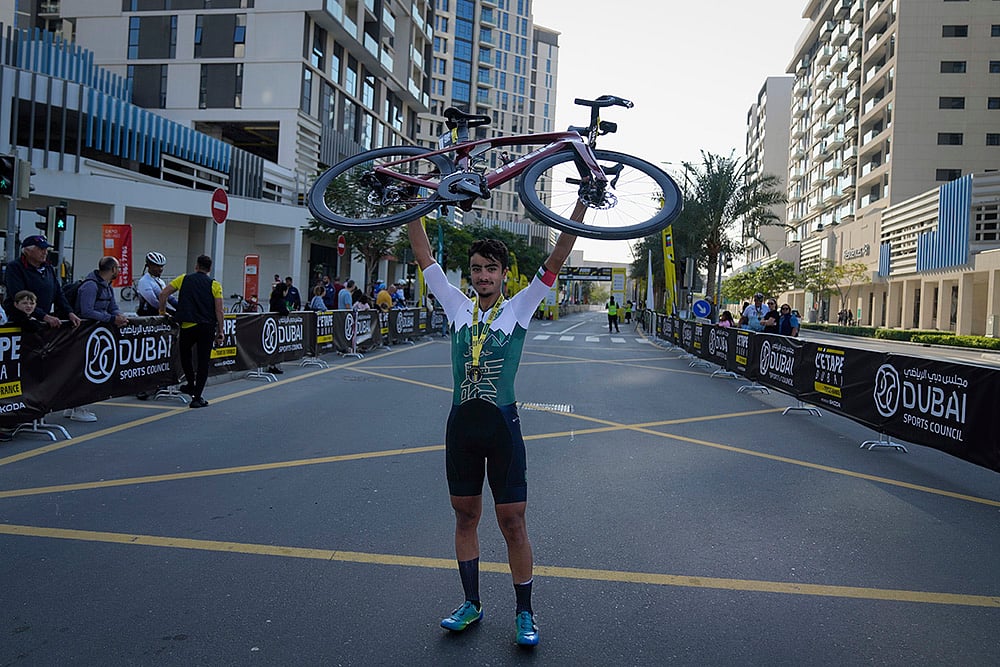 | Photo: AP/Altaf Qadri : Emirates Cycling: Ibrahiem Alrefai of Syria lifts his bicycle after winning the L'Etape Dubai