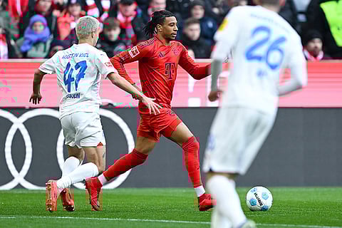 Bundesliga 2024-25: Bayern's Michael Olise and John Tolkin, left, challenge for the ball