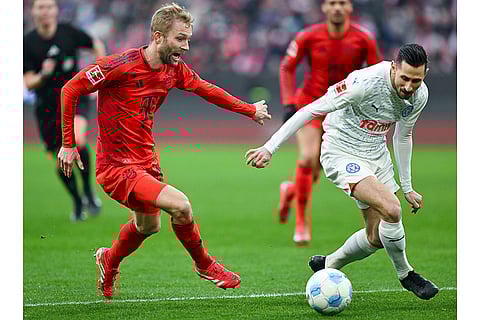 Bundesliga 2024-25: Bayern's Konrad Laimer and Kiel's Steven Skrzybski challenge for the ball