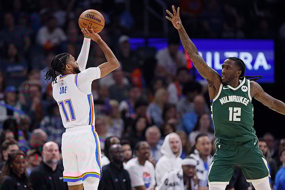 | Photo: AP/Nate Billings : NBA 2024-25: Thunder guard Isaiah Joe (11) looks to shoot over Bucks forward Taurean Prince