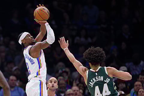 NBA 2024-25: City guard Shai Gilgeous-Alexander looks to shoot over Milwaukee guard Andre Jackson Jr.