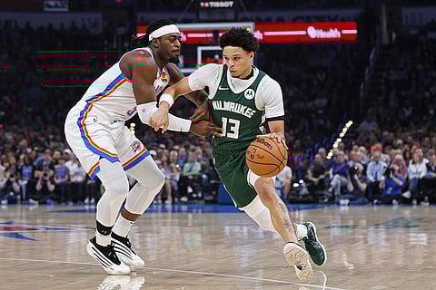 NBA 2024-25: Milwaukee guard Ryan Rollins (13) drives against Oklahoma City guard Luguentz Dort