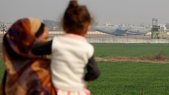 | Photot-  Reuters : People look at a US military plane deporting Indian immigrants as it lands in Amritsar.