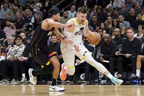 NBA 2024-25: Jazz center Micah Potter (25) drives on Suns guard Devin Booker