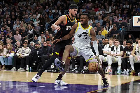 NBA 2024-25: Jazz guard Isaiah Collier (13) shields the ball from Suns guard Devin Booker