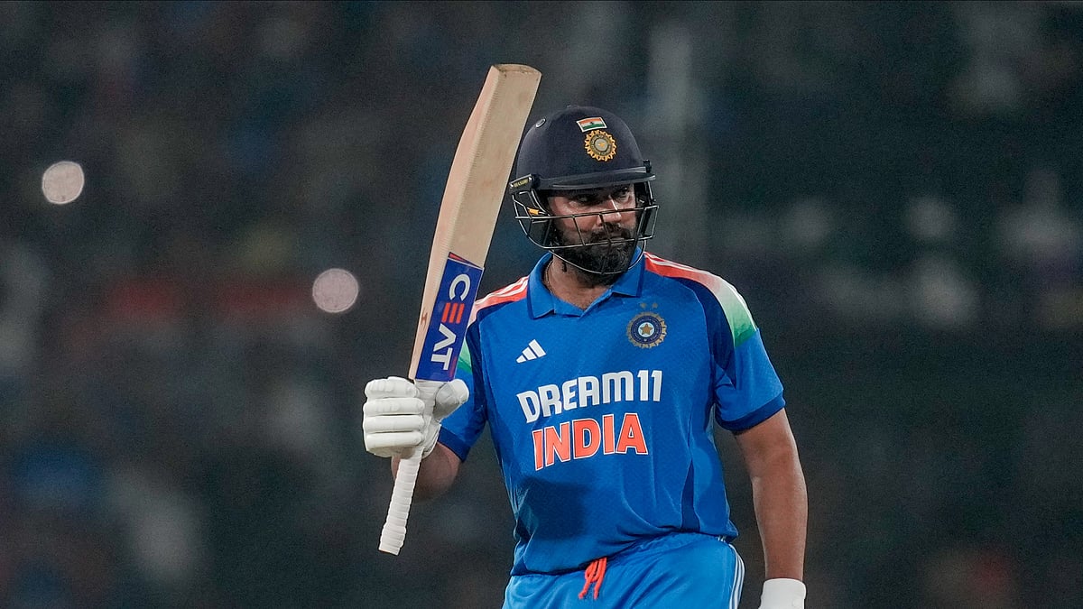 AP Photo/Rafiq Maqbool : India's captain Rohit Sharma raises his bat as he celebrates after scoring a century during the second one-day international cricket match between India and England in Cuttack.