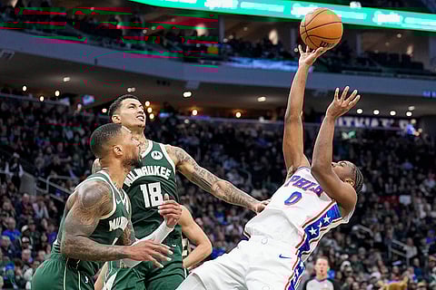 NBA 2024-25: 76ers' Tyrese Maxey (0) shoots against Bucks' Damian Lillard and Kyle Kuzma