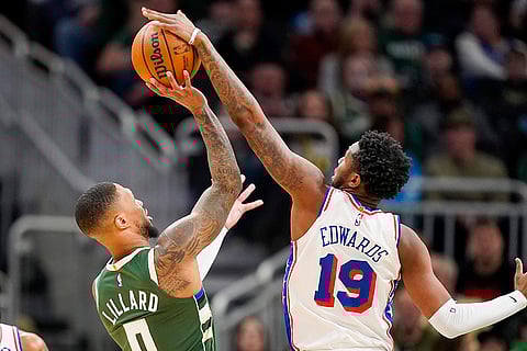 NBA 2024-25: 76ers' Justin Edwards (19) blocks Bucks' Damian Lillard