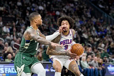 NBA 2024-25: Bucks' Damian Lillard (0) reaches in against 76ers' Kelly Oubre Jr.