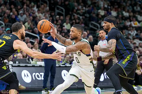 NBA 2024-25: Bucks' Damian Lillard (0) looks to pass the ball