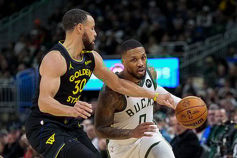 NBA 2024-25: Bucks' Damian Lillard (0) controls the ball against against Warriors' Stephen Curry