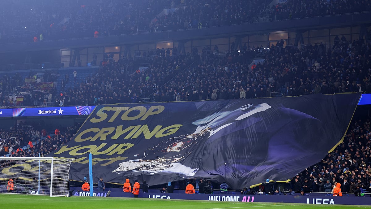 Manchester City fans parade a banner mocking Vinicius Junior