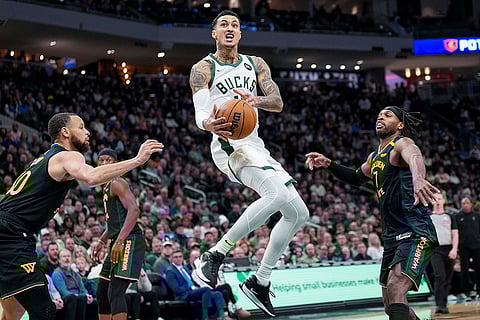 NBA 2024-25: Bucks' Kyle Kuzma (18) goes up to shoot against Warriors' Stephen Curry