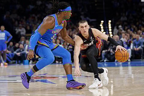 NBA 2024-25: Heat guard Tyler Herro drives against Thunder guard Luguentz Dort