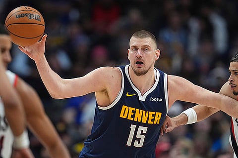 NBA 2024-25: Nuggets center Nikola Jokic fields a pass as Trail Blazers forward Toumani Camara defends