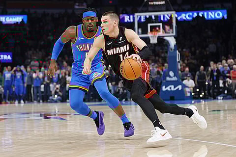 NBA 2024-25: Heat guard Tyler Herro (14) drives against Thunder guard Luguentz Dort