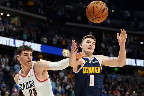 NBA 2024-25: Nuggets Christian Braun pursues a loose ball with Trail Blazers Donovan Clingan