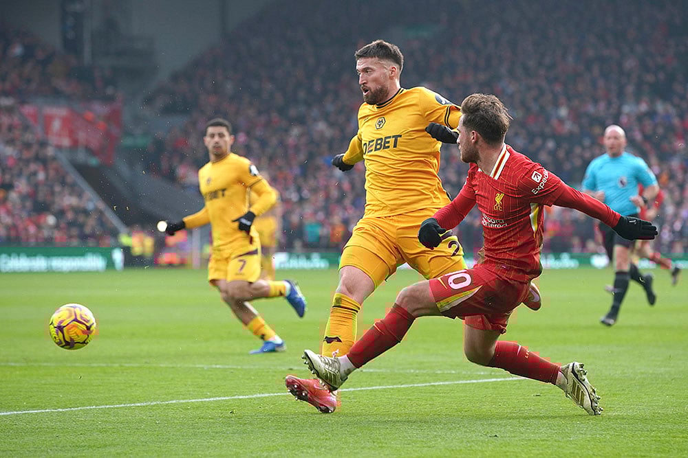 | Photo: AP/Ian Hodgson : EPL 2024-25: Liverpool's Alexis Mac Allister kicks the ball ahead of Wolves' Matt Doherty