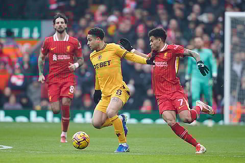 EPL 2024-25: Wolves' Joao Gomes, centre, challenges for the ball with Liverpool's Luis Diaz