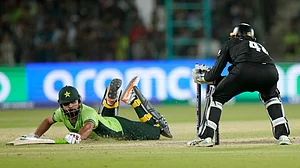 AP Photo/Anjum Naveed : Pakistan's Khushdil Shah, left, dives to safe his run out during the ICC Champions Trophy cricket match between Pakistan and New Zealand, in Karachi.