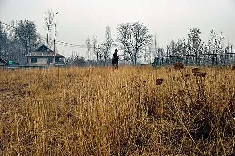 Mohammad Amin stands in a graveyard and prays for the deceased