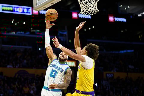 NBA 2024-25: Hornets forward Miles Bridges (0) shoots while defended by Lakers center Jaxson Hayes