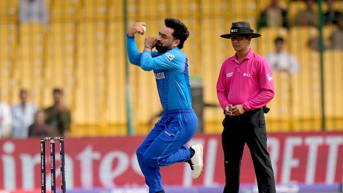 AP Photo/Anjum Naveed : Afghanistan's Rashid Khan, centre, bowls as Bangladesh's umpire Sharfuddoula watches during the ICC Champions Trophy cricket match between Afghanistan and South Africa, in Karachi.