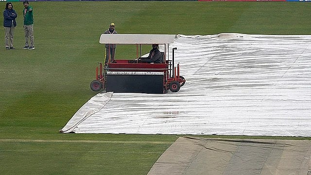AP : A groundsman drives super sopper to remove water from the covers during the Australia vs South Africa game. 