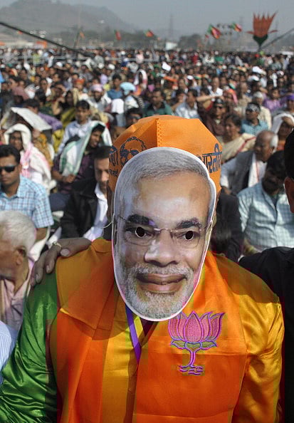 Getty Images : Bharatiya Janata Party (BJP) supporter wears a mask of BJP prime ministerial candidate and western Gujarat state Chief Minister, Narendra Modi during an election rally addressed by Modi in Guwahati on February 8, 2014.
