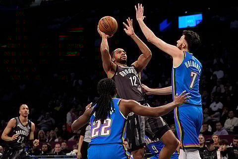 NBA 2024-25: Brooklyn Nets' Tosan Evbuomwan (12) shoots over Thunder players