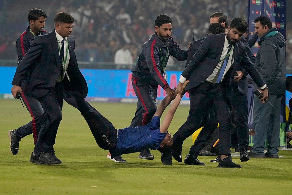 | Photo: AP/K.M. Chaudary : CT 2025, AFG vs ENG: Security officers carry a pitch invader 