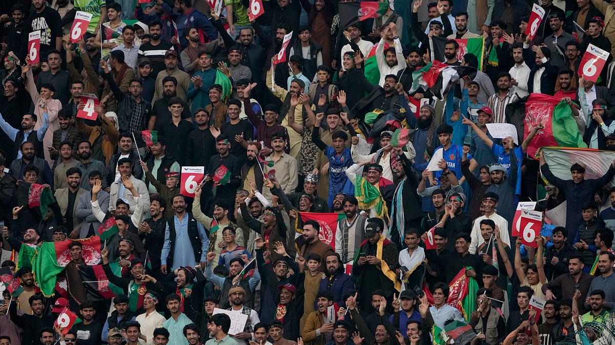 AP Photo/K.M. Chaudary : Fans cheer for their team during the ICC Champions Trophy cricket match between Australia and Afghanistan, in Lahore.