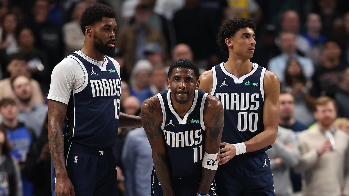 Injured Dallas Mavericks guard Kyrie Irving (center) is aided by teammates Naji Marshall (left) and Max Christie on March 3, 2025. - null