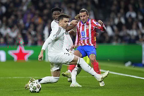 UCL 2024-25 Round Of 16 First leg, RMA vs ATM: Antoine Griezmann, right, is challenged by Real Madrid's Raul Asencio and Aurelien Tchouameni